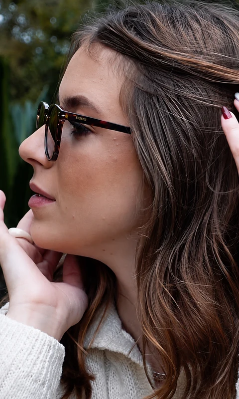 Sara usando óculos escuros de armação estampada, vista de perfil